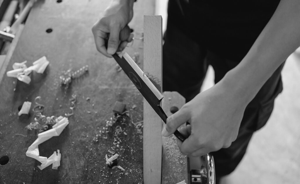 A carpenter demonstrating a carpentry technique wood carving