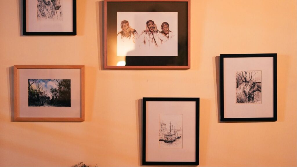 a gallery wall with a mix of art pieces in different sizes and frames