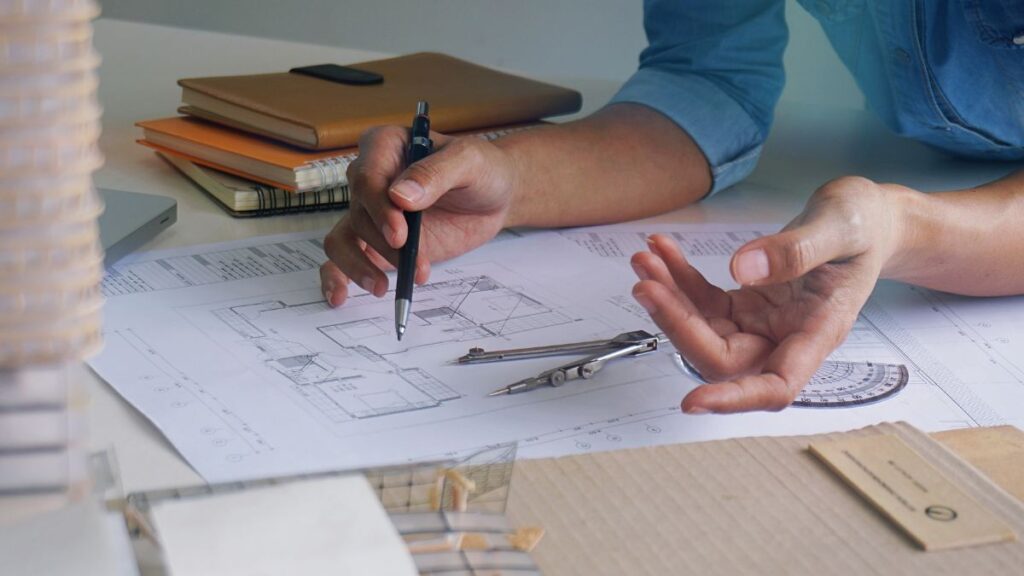 an image of a hand sketching an interior design layout