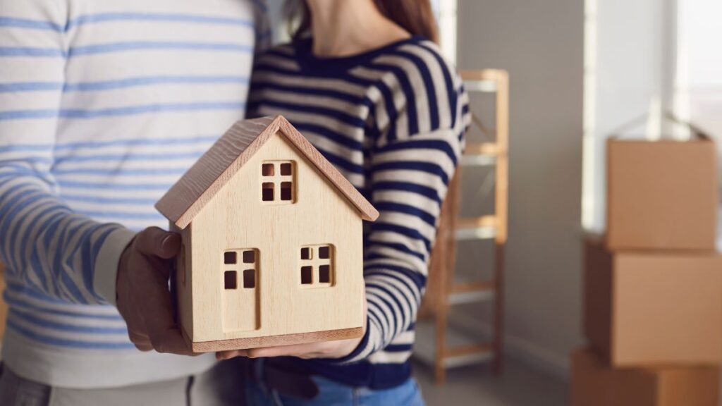 couple holding 3d model of house